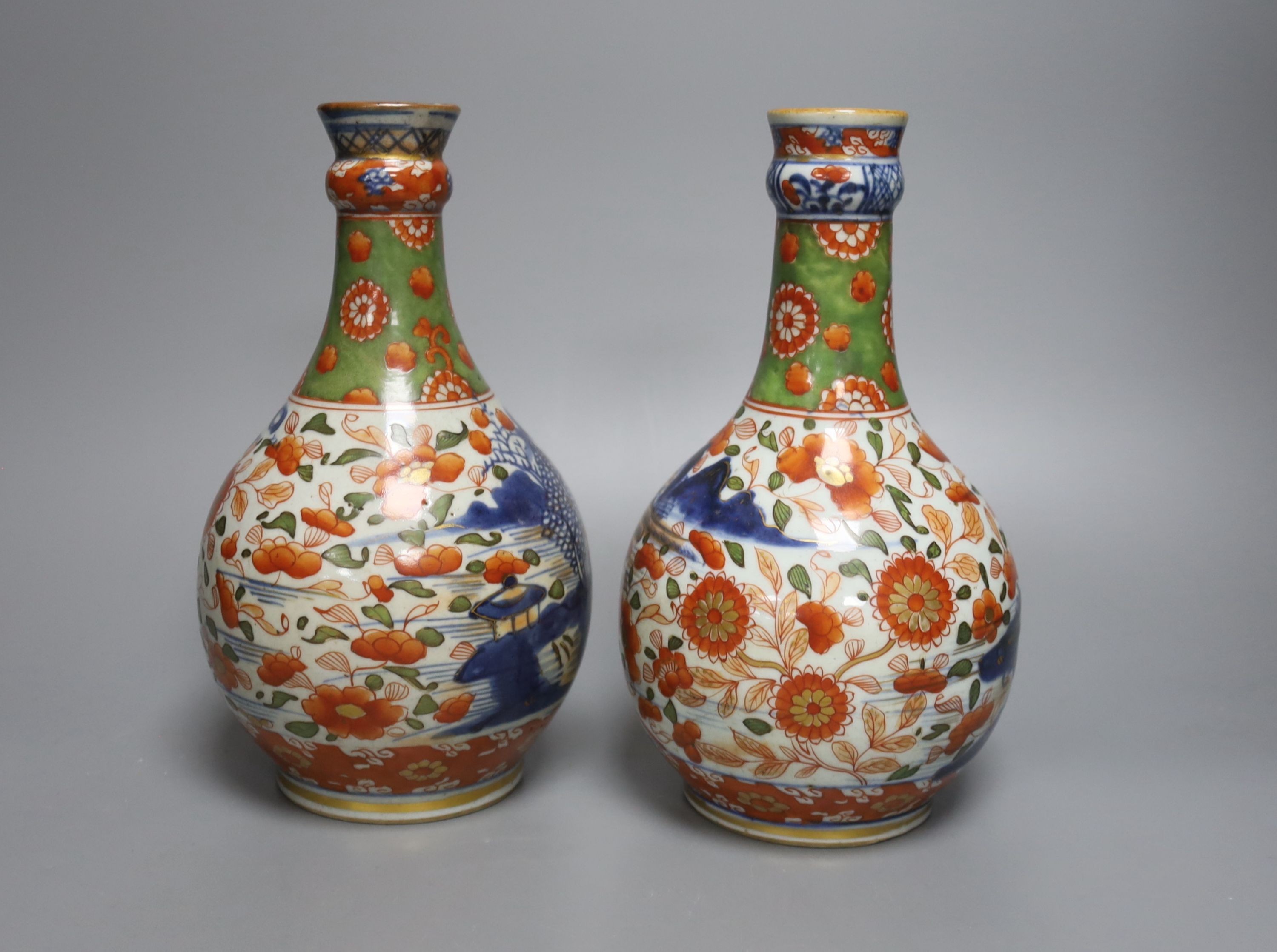 A pair of 18th century Chinese clobbered blue and white bottle vases 23cm